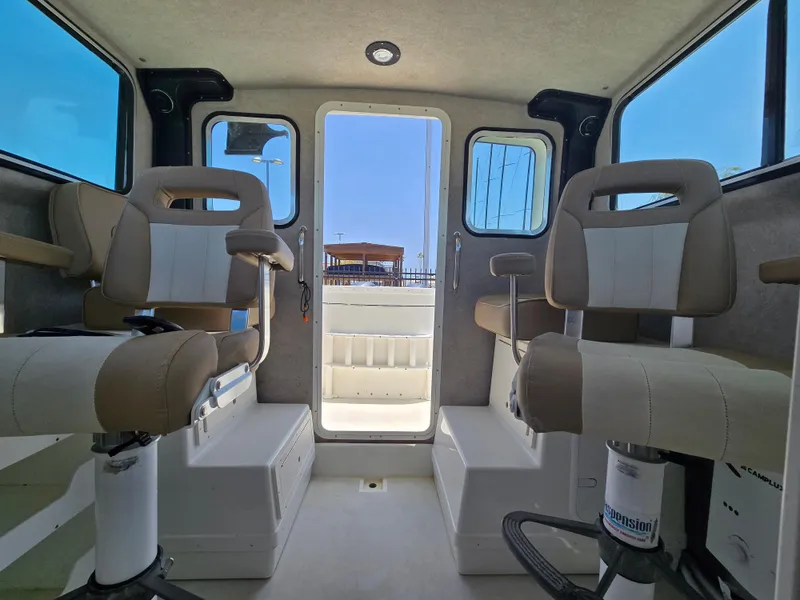 Slide: The Image of Interior of a 2019 Parker 2520 DV boat with beige seating and open rear door. - 36