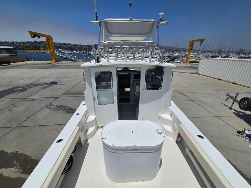 Slide: The Image of 2019 Parker 2520 DV boat docked at marina, featuring spacious deck and cabin. - 4