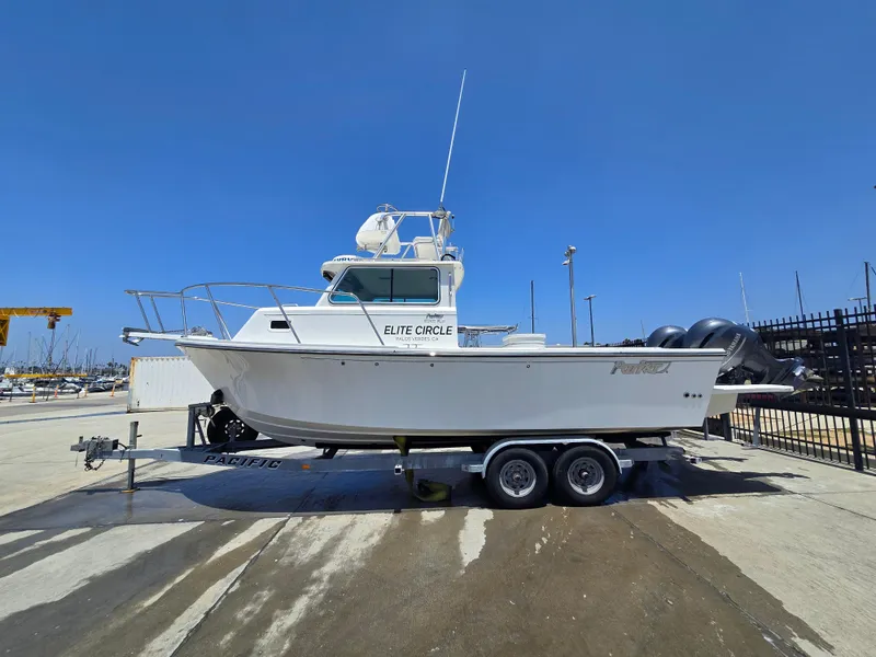 Slide: The Image of 2019 Parker 2520 DV boat on trailer at marina under clear blue sky. - 47