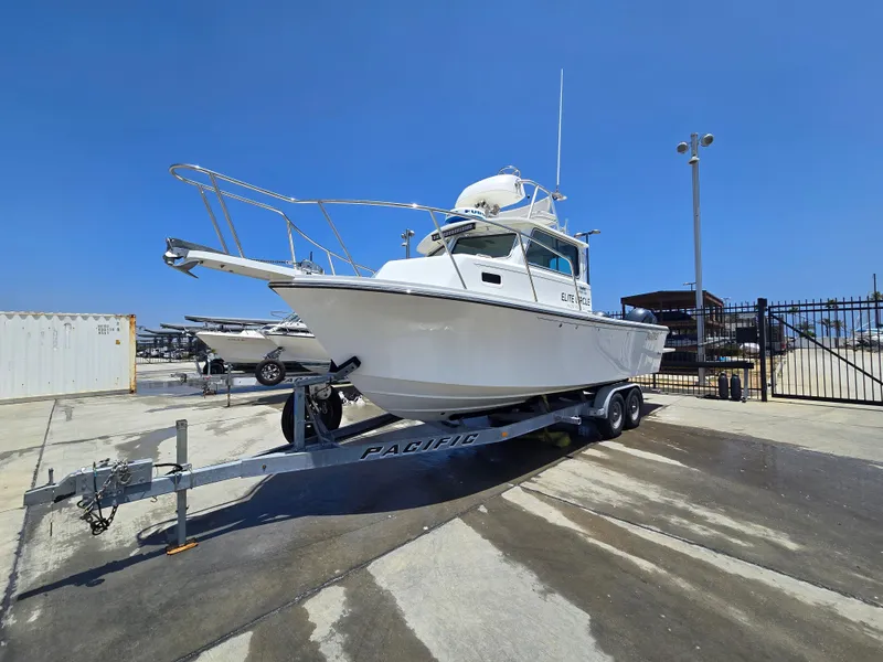 Slide: The Image of 2019 Parker 2520 DV boat on trailer in marina under clear blue sky. - 48