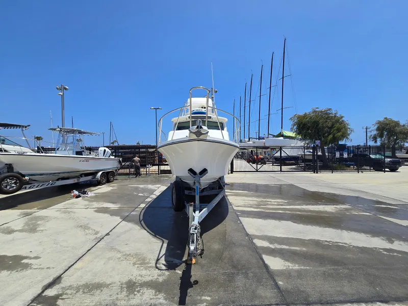 Slide: The Image of 2019 Parker 2520 DV boat on trailer at marina under clear blue sky. - 49