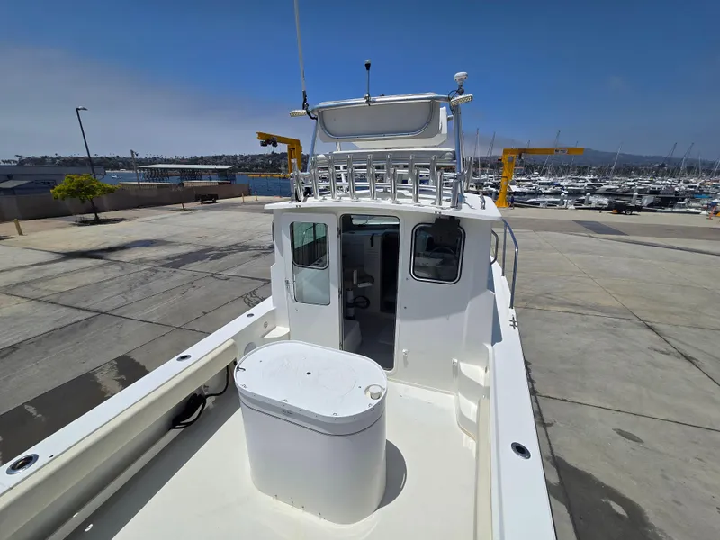 Slide: The Image of 2019 Parker 2520 DV boat docked at marina with clear sky background. - 5
