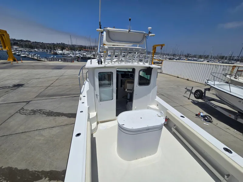 Slide: The Image of 2019 Parker 2520 DV boat docked at marina with clear sky background. - 6