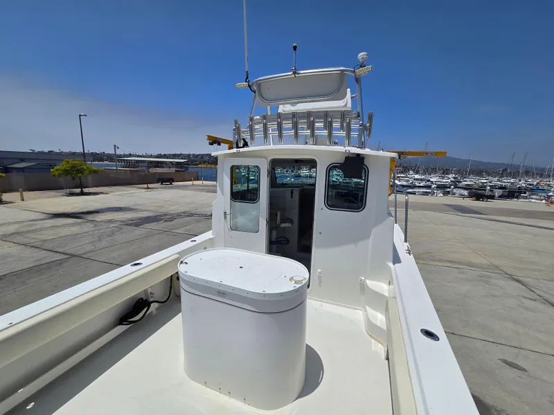Slide: The Image of 2019 Parker 2520 DV boat docked at marina under clear blue sky. - 7