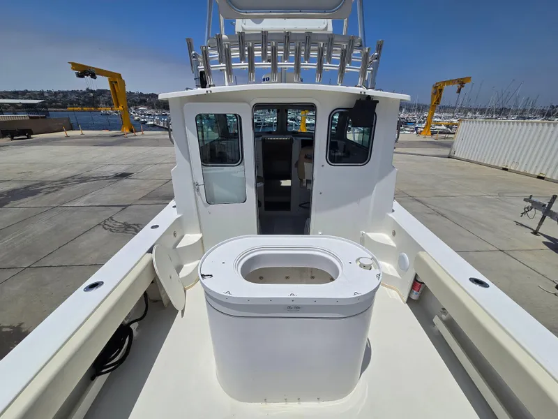 Slide: The Image of 2019 Parker 2520 DV boat on dock, featuring spacious deck and cabin. - 9