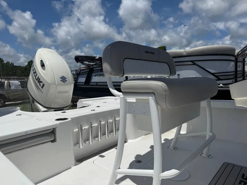 Slide: The Image of 2018 Sea Pro 228 Bay boat interior with Suzuki engine, under a cloudy sky. - 5