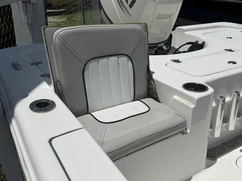 Slide: The Image of 2018 Sea Pro 228 Bay boat seat with cup holders and engine in background. - 8