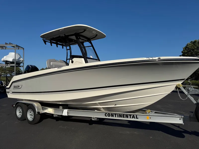 Slide: The Image of 2025 Boston Whaler 230 Outrage boat on trailer under clear blue sky. - 3