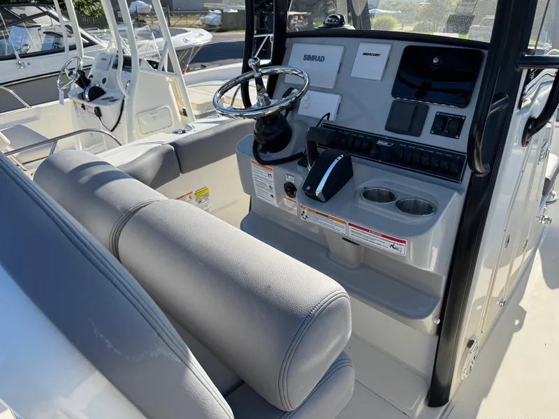 Slide: The Image of 2025 Boston Whaler 230 Outrage boat console with steering wheel and controls. - 6