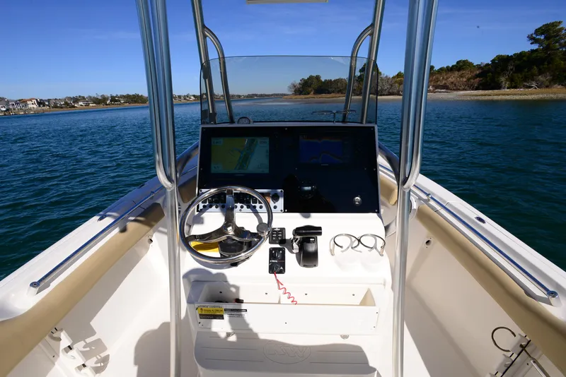 Slide: The Image of 2020 Key West 219 FS boat dashboard with steering wheel and navigation system on open water. - 11