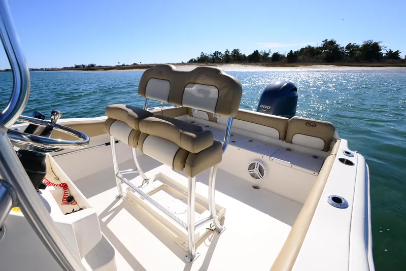Slide: The Image of 2020 Key West 219 FS boat interior with seating, steering wheel, and ocean view. - 12
