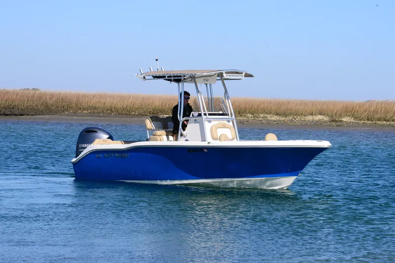 Slide: The Image of 2020 Key West 219 FS boat cruising on calm water with scenic background. - 2