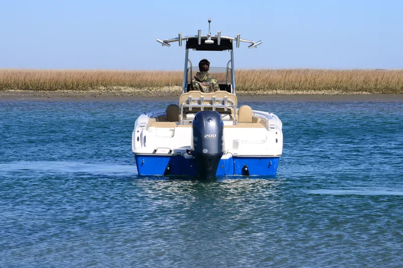 Slide: The Image of 2020 Key West 219 FS boat on water, with outboard motor, near marshland. - 6