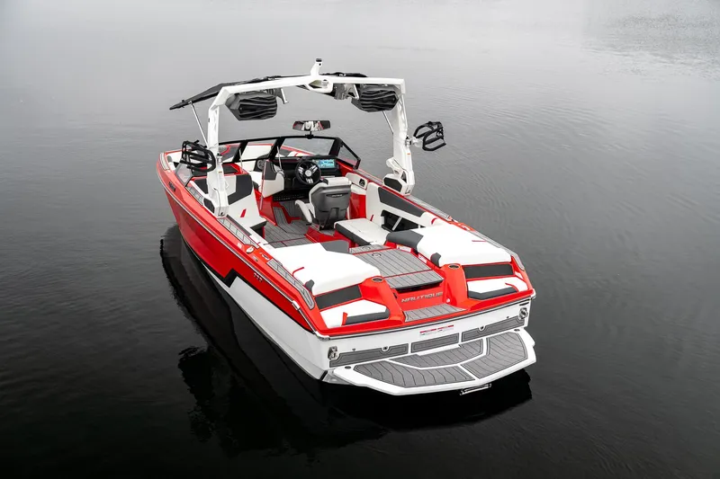 Slide: The Image of 2026 Nautique Super Air Nautique GS22 boat on calm water, red and white design. - 13