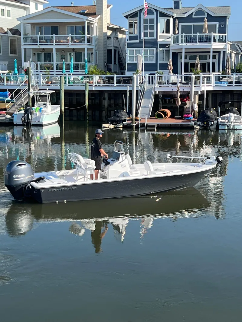 Slide: The Image of 2023 Sportsman Masters 207 Bay Boat on calm water near waterfront homes. - 1