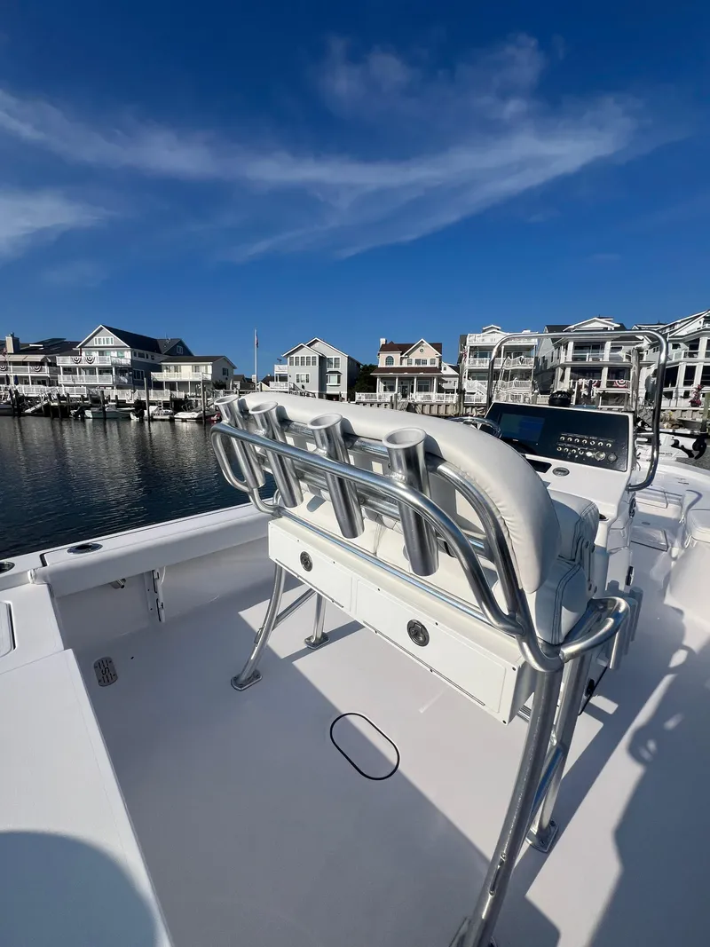 Slide: The Image of 2023 Sportsman Masters 207 Bay Boat docked near waterfront homes under clear blue sky. - 11