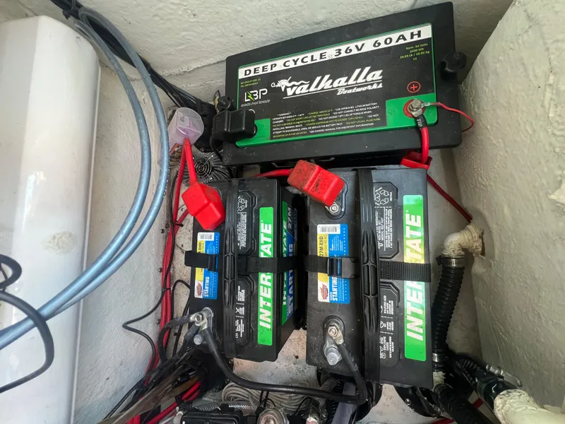 Slide: The Image of Battery setup in a 2023 Sportsman Masters 207 Bay Boat, featuring deep cycle and Interstate batteries. - 13