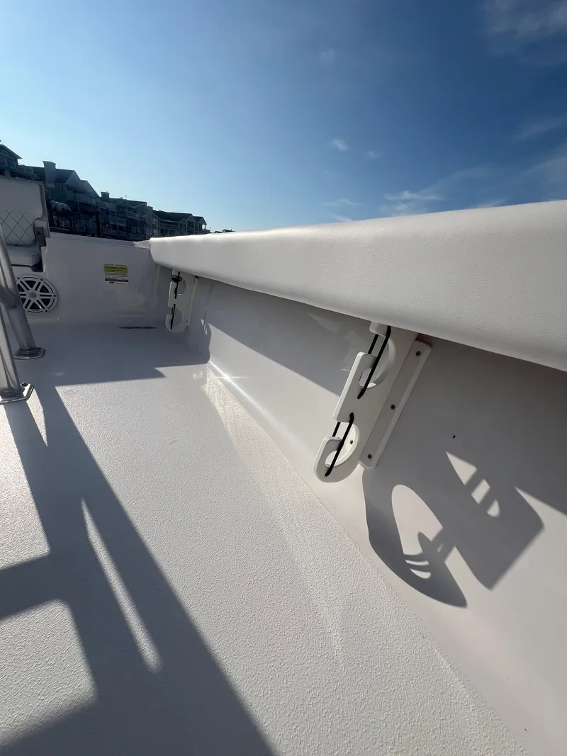 Slide: The Image of 2023 Sportsman Masters 207 Bay Boat interior with white seating and clear blue sky. - 14