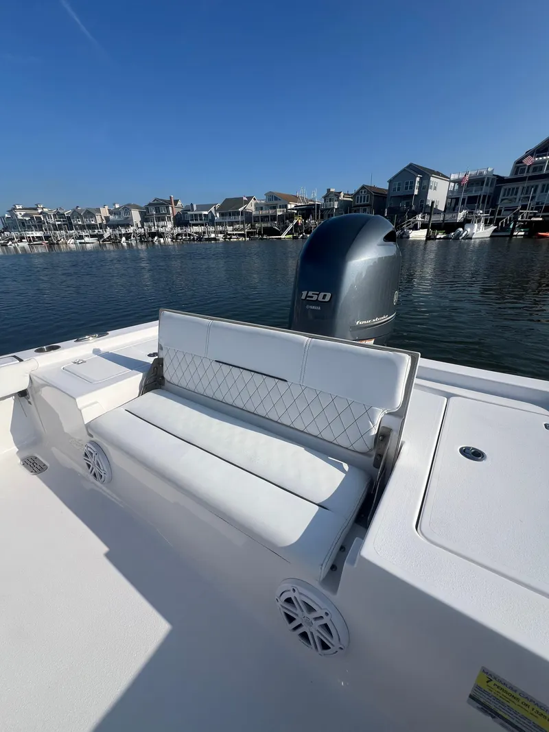 Slide: The Image of 2023 Sportsman Masters 207 Bay Boat with Yamaha 150 engine, docked near waterfront homes. - 15