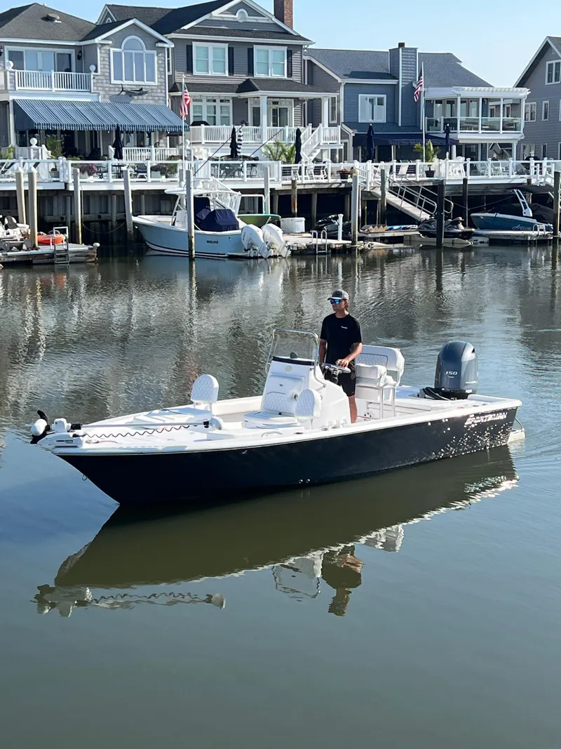 Slide: The Image of 2023 Sportsman Masters 207 Bay Boat cruising near waterfront homes. - 2