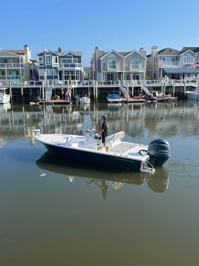 Slide: The Image of 2023 Sportsman Masters 207 Bay Boat on calm water near waterfront homes. - 3