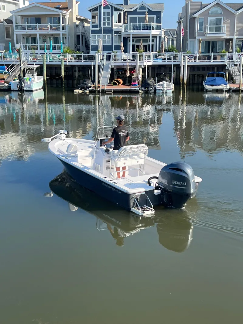 Slide: The Image of 2023 Sportsman Masters 207 Bay Boat cruising near waterfront homes. - 4