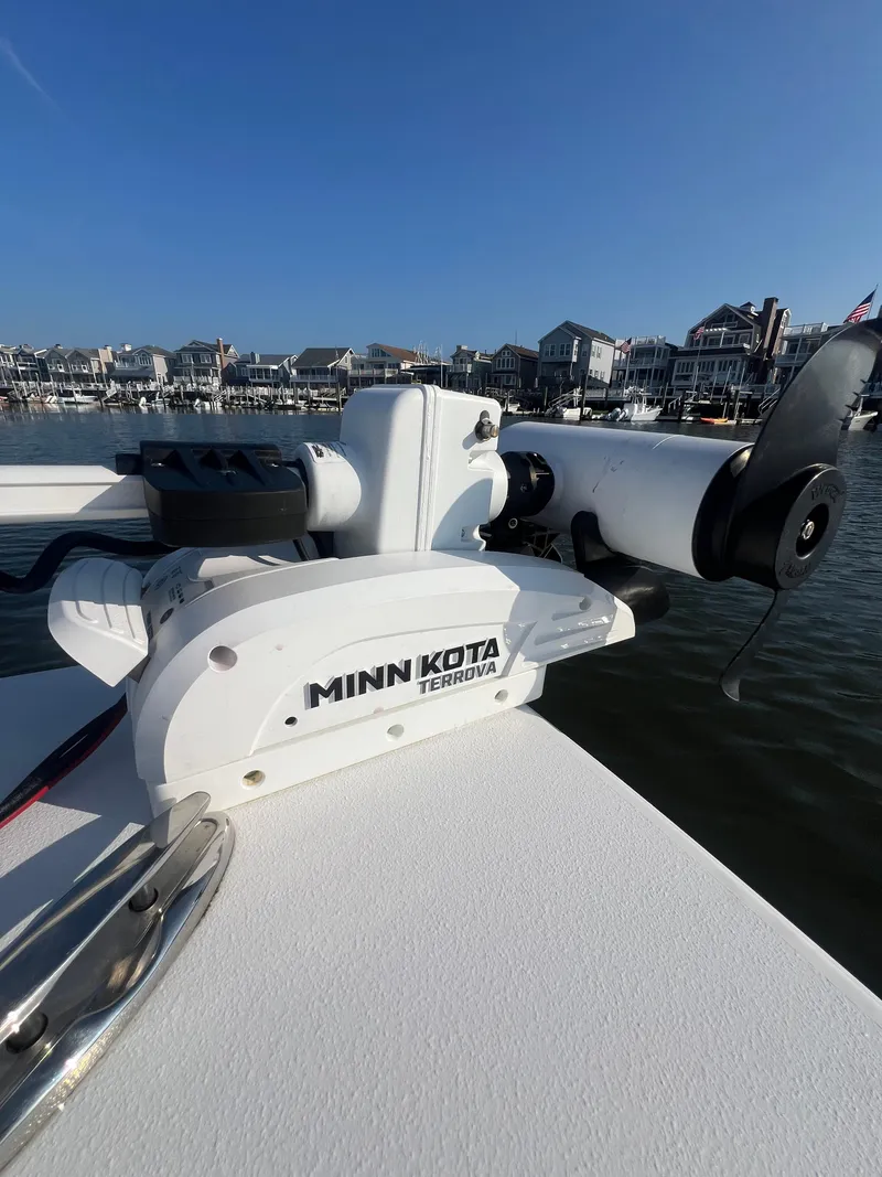 Slide: The Image of 2023 Sportsman Masters 207 Bay Boat with Minn Kota Terrova motor, docked near waterfront homes. - 5
