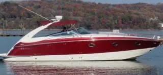 Slide: The Image of 2005 Cobalt 360 boat with red and white design on a calm lake. - 2