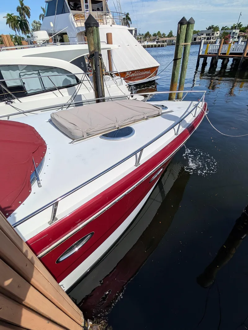 Slide: The Image of 2005 Cobalt 360 boat docked, featuring red and white exterior, calm marina setting. - 3