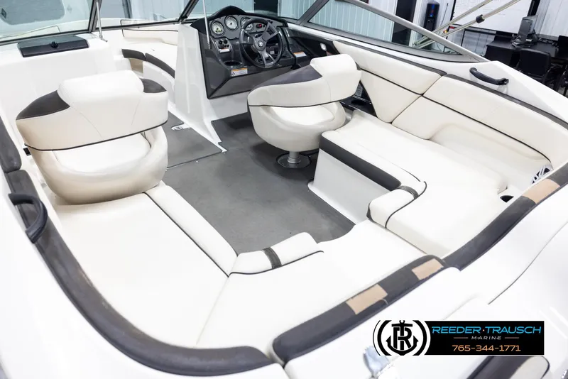 Slide: The Image of Interior of a 2013 Yamaha Boats 210 SX, featuring sleek white seating and modern dashboard. - 11