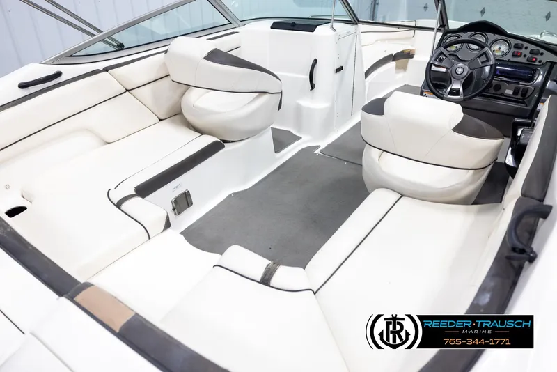 Slide: The Image of Interior of 2013 Yamaha Boats 210 SX, featuring white seating and modern dashboard. - 12