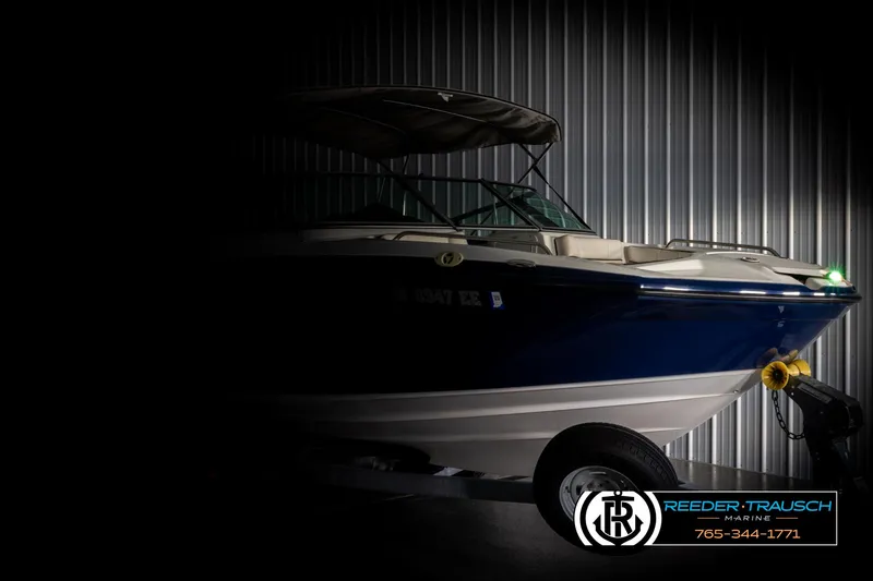 Slide: The Image of 2013 Yamaha Boats 210 SX in a dimly lit showroom, showcasing sleek design. - 4