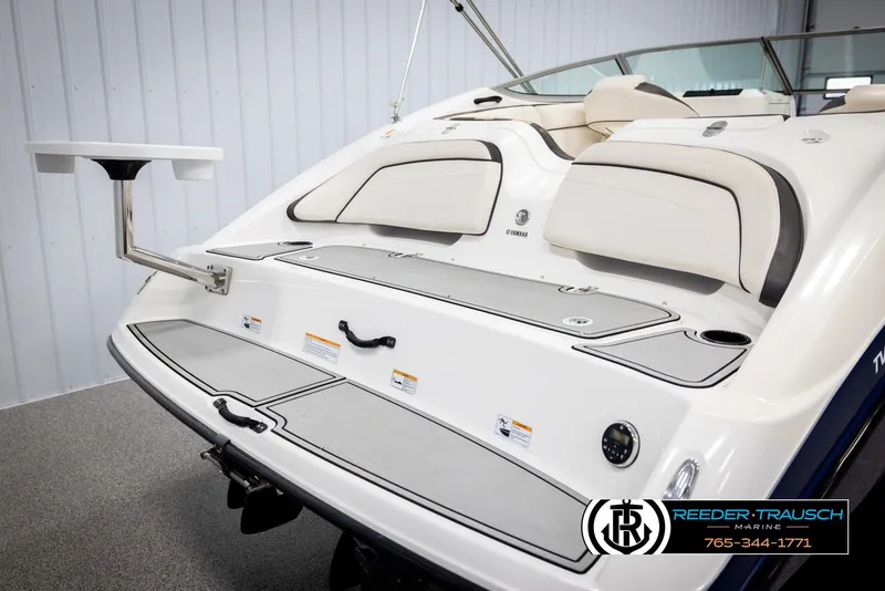 Slide: The Image of 2013 Yamaha Boats 210 SX with swim platform and seating, displayed indoors. - 46