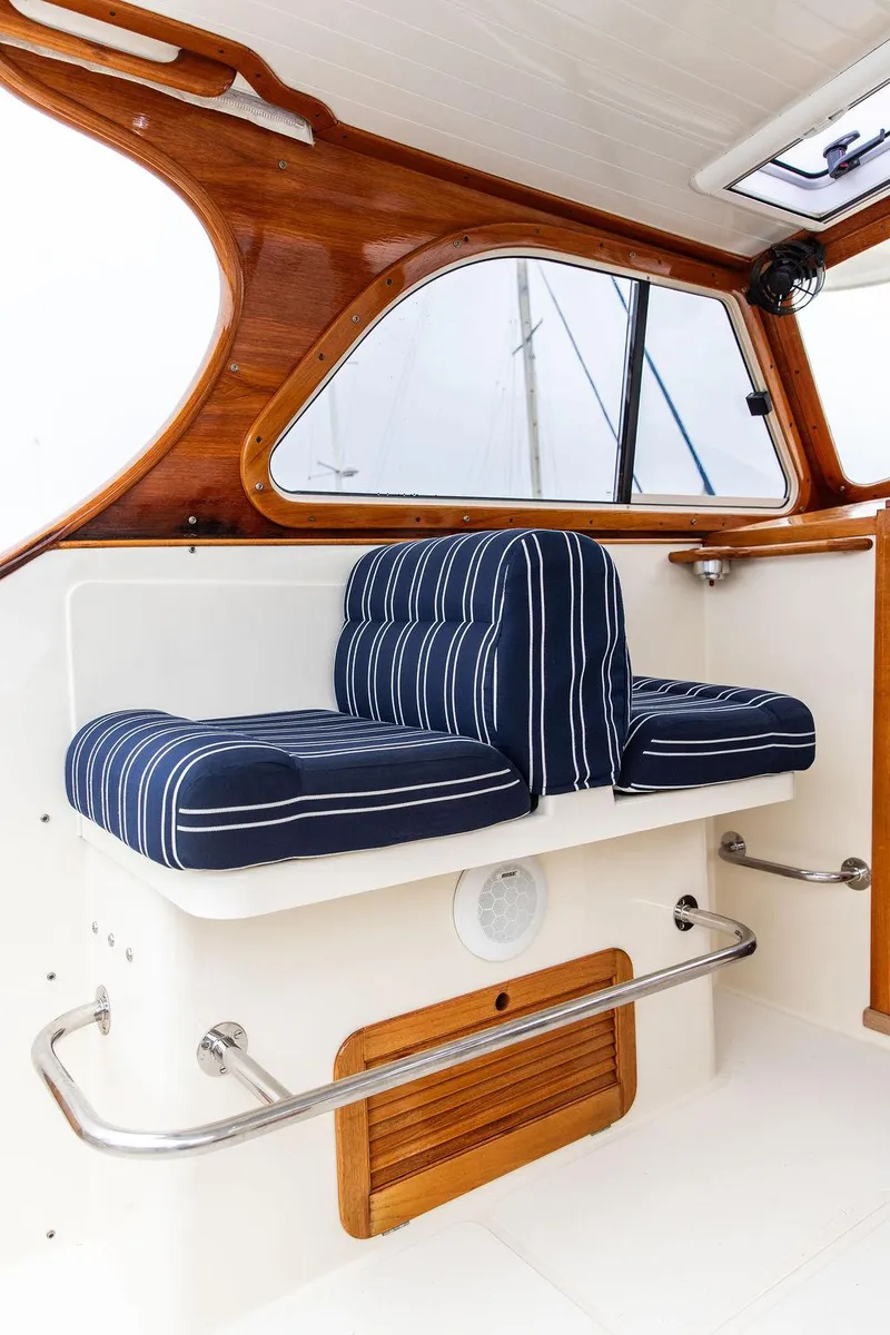 Slide: The Image of 1999 Hinckley Picnic Boat Classic interior with striped cushions and wooden accents. - 13
