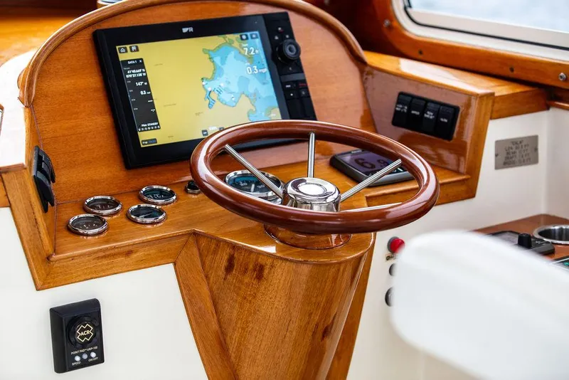 Slide: The Image of 1999 Hinckley Picnic Boat Classic helm with wooden steering wheel and navigation display. - 15