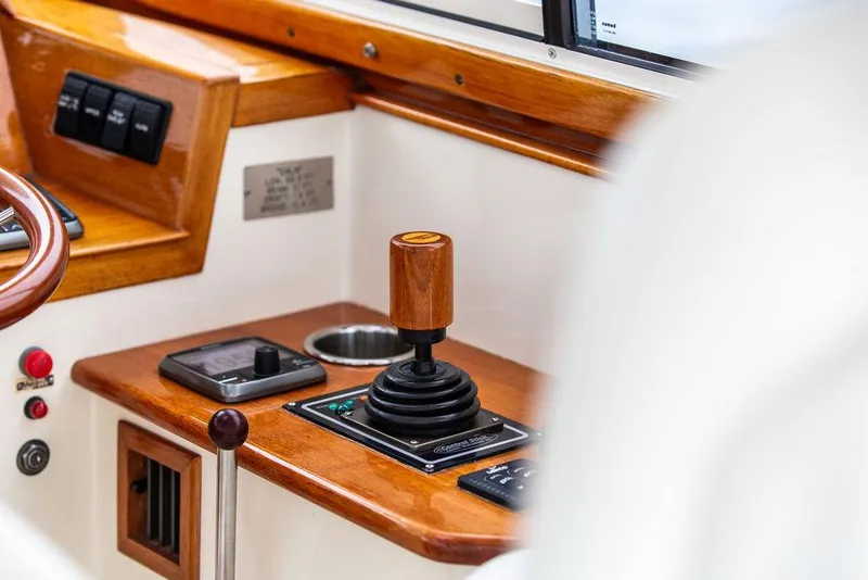 Slide: The Image of 1999 Hinckley Picnic Boat Classic helm with joystick control and wooden accents. - 16