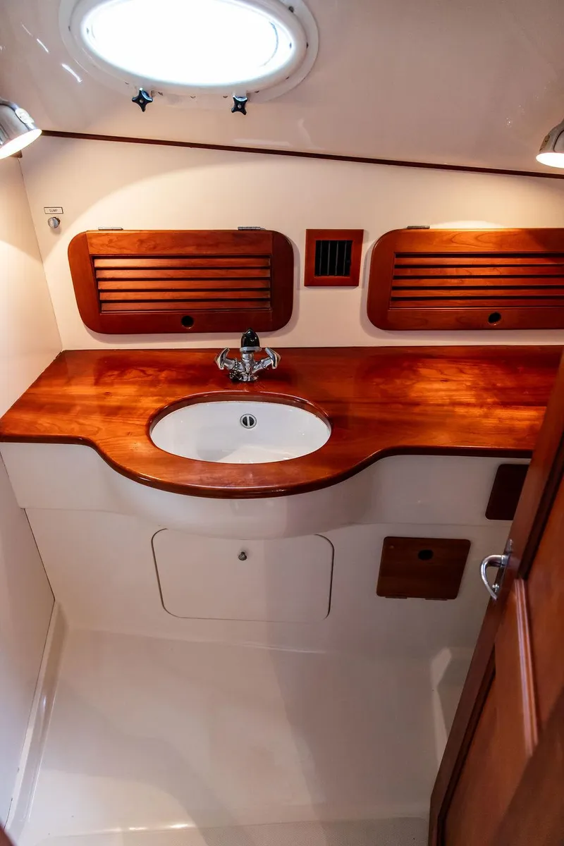 Slide: The Image of 1999 Hinckley Picnic Boat Classic bathroom with wooden cabinetry and sink. - 20