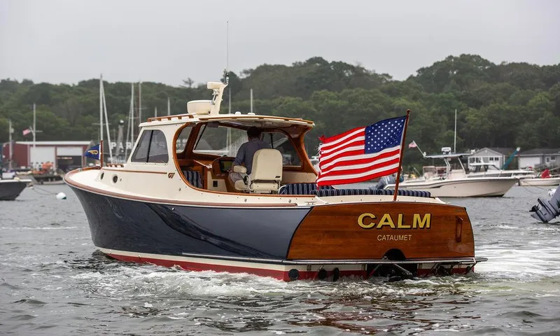 Slide: The Image of 1999 Hinckley Picnic Boat Classic with American flag, cruising in a marina. - 6