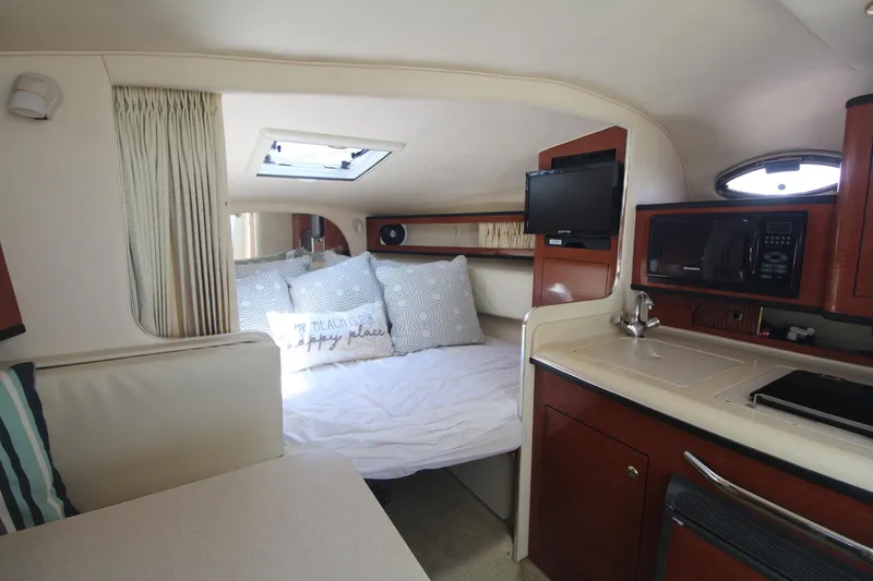 Slide: The Image of Interior of 2004 Sea Ray 280 Sundancer with cozy bed, kitchenette, and TV. - 11