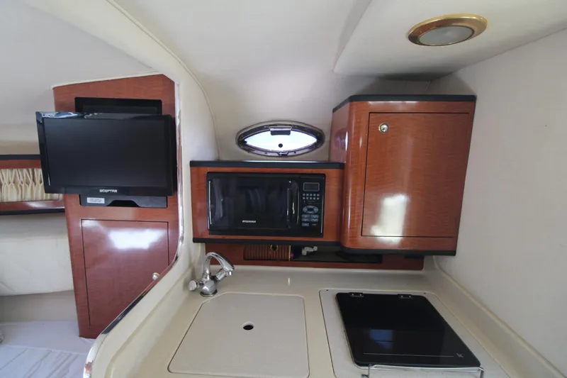 Slide: The Image of Interior of 2004 Sea Ray 280 Sundancer with kitchenette, TV, and microwave. - 14