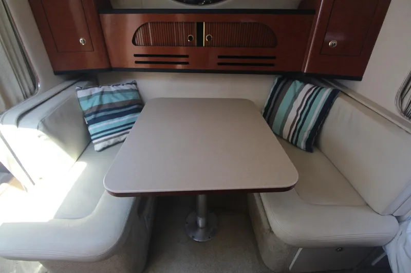 Slide: The Image of Interior of 2004 Sea Ray 280 Sundancer with cozy seating and striped cushions. - 15