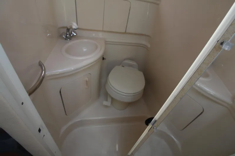 Slide: The Image of 2004 Sea Ray 280 Sundancer bathroom with sink, toilet, and shower area. - 22