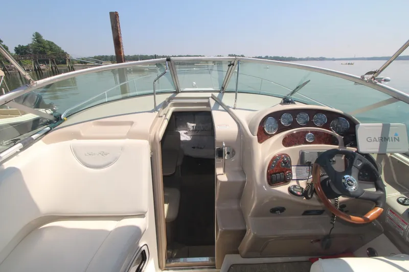 Slide: The Image of 2004 Sea Ray 280 Sundancer cockpit with Garmin navigation, steering wheel, and instrument panel. - 3