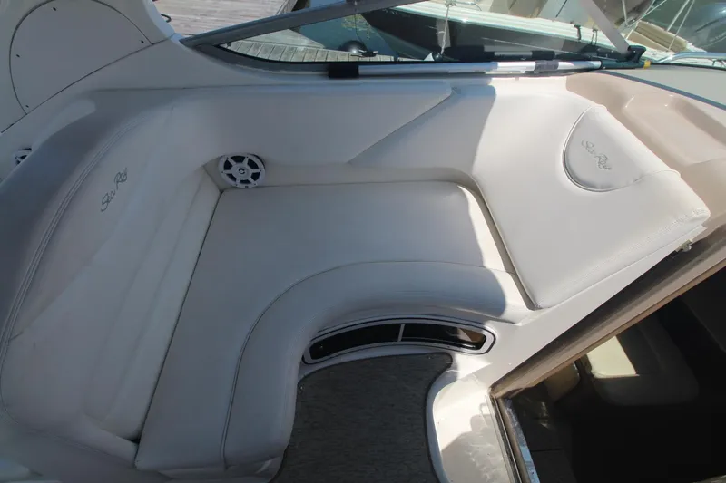 Slide: The Image of 2004 Sea Ray 280 Sundancer interior seating with white upholstery and speaker. - 6