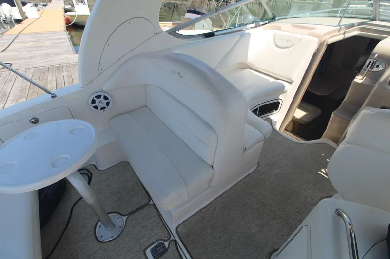 Slide: The Image of 2004 Sea Ray 280 Sundancer interior with seating and table, docked at marina. - 8