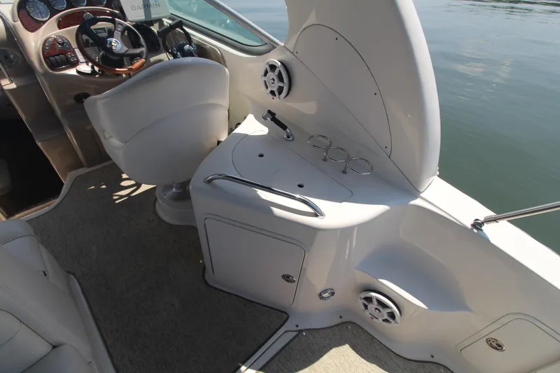 Slide: The Image of 2004 Sea Ray 280 Sundancer cockpit with helm, seating, and control panel. - 9