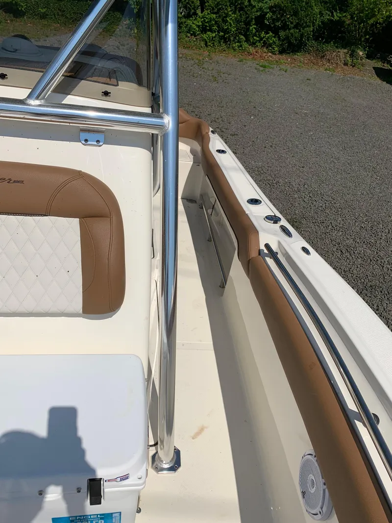 Slide: The Image of 2026 Pioneer 222 Islander boat interior with tan and white seating, stainless steel railing. - 10