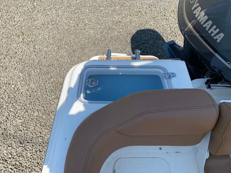 Slide: The Image of 2026 Pioneer 222 Islander boat with Yamaha engine, featuring a tan seat and storage compartment. - 14