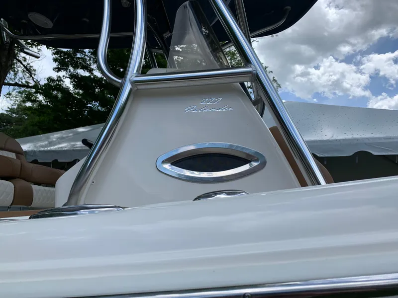 Slide: The Image of 2026 Pioneer 222 Islander boat, sleek design, chrome details, under cloudy sky. - 19