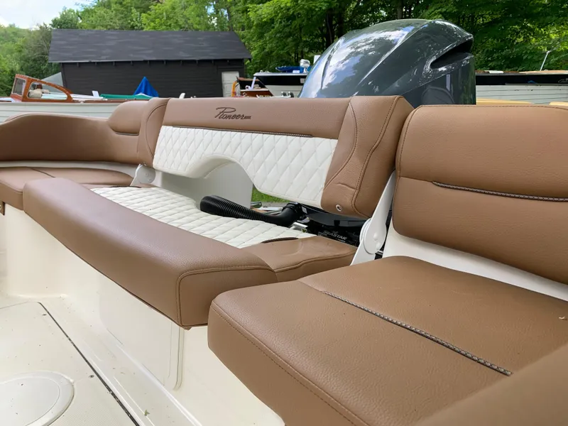 Slide: The Image of 2026 Pioneer 222 Islander boat with brown leather seating and white accents. - 21